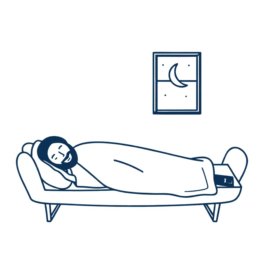 A man asleep on a sofa at night, his phone quiet on the table